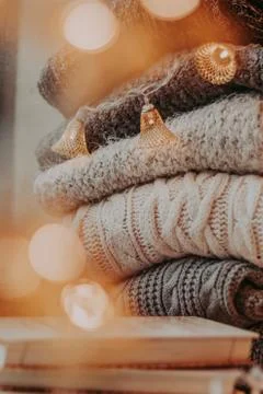 A bunch of sweaters, light bulbs, lanterns, cozy winter interior details, hom Stock Photos