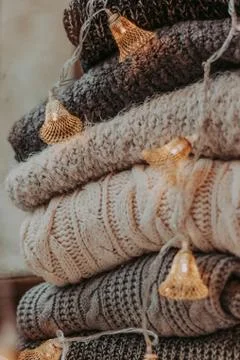 A bunch of sweaters, light bulbs, lanterns, cozy winter interior details, hom Stock Photos
