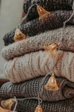 A bunch of sweaters, light bulbs, lanterns, cozy winter interior details, hom Stock Photos