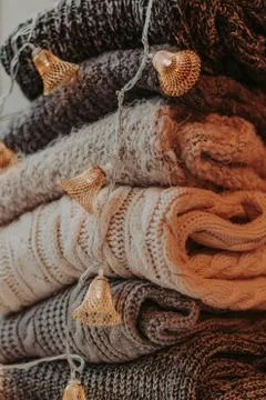 A bunch of sweaters, light bulbs, lanterns, cozy winter interior details, hom Stock Photos