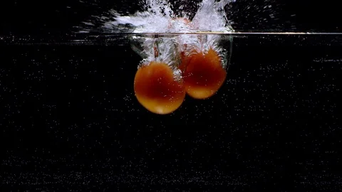 Bunch of Tomatoes falling into water in slow motion. Isolated on black 스톡 동영상 124833096