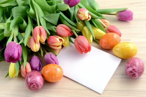 Bunch of tulips with easter eggs and note paper copy space Stock Photos