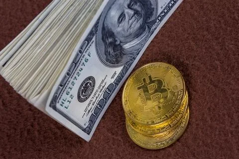Bunch of us dollar banknotes and three bitcoin shiners on brown fleece Stockfoto's