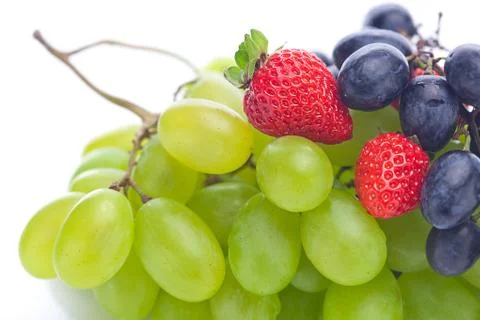 Bunch of white and black grapes and strawberries isolated on white Stock Photos