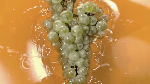 Bunch of white grapes falls into grape juice and splashes fly in slow motion. Stock-Footage 268743935