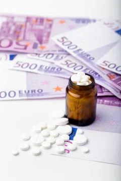 Bunch of white tablets with banknotes Stock Photos