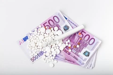 Bunch of white tablets with banknotes Stock Photos
