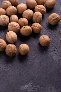 Bunch of whole walnuts on dark blue slate background. Healthy diet composition. Stock Photos
