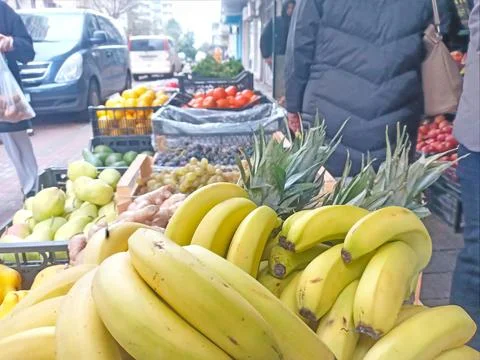 A bunch of yellow bananas on a background of different fruits Foto stock