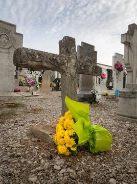 Bunch of yellow begonia on a cemetery cross Stock Photos