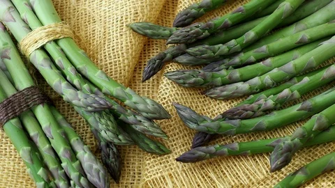 Bunches of asparagus tied with twine on a burlap background. Stock Footage 93174111