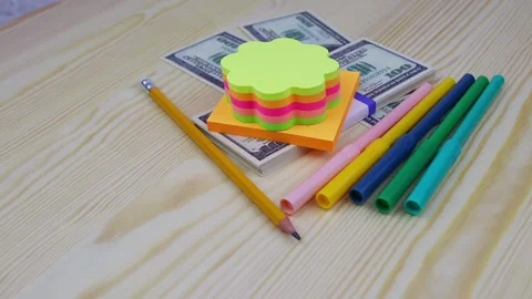 A bundle of 100 dollars bills with stationery rotates on a round wooden table Vídeo Stock 142164392