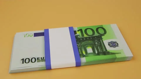 Bundle of 100 euros falls on the table and the hand puts the rolled bills on top Stock Footage 143083641