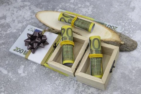 A bundle of 200 euro banknotes in small wooden boxes and on decorative wood cuts Stock Photos