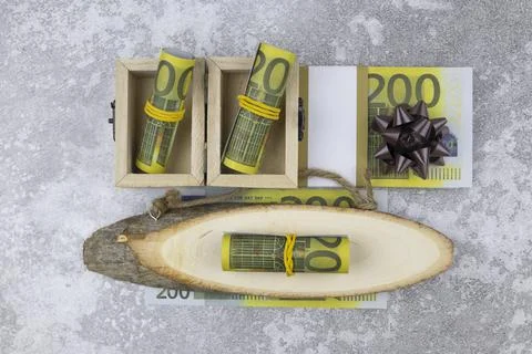A bundle of 200 euro banknotes in small wooden boxes and on decorative wood cuts Stock-Fotos