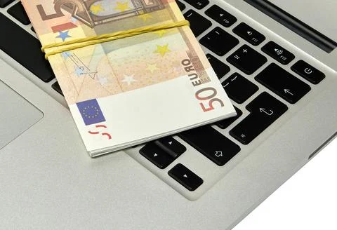 A bundle of 50 euro bills lying on a computer keyboard Stock Photos