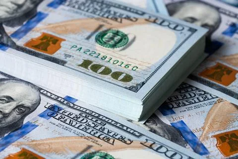 A bundle and a roll of dollars on bills of one hundred dollars. Stock Photos