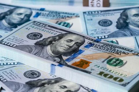 A bundle and a roll of dollars on bills of one hundred dollars. Stock Photos