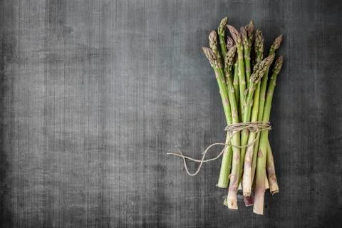 A bundle of asparagus on a grey surface Stock Photos