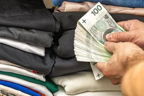 A bundle of banknotes hidden from thieves among the clothes in the wardrobe.. Stock Photos