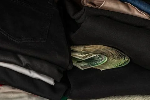 A bundle of banknotes rolled up and hidden from thieves among the clothes i.. Stock Photos