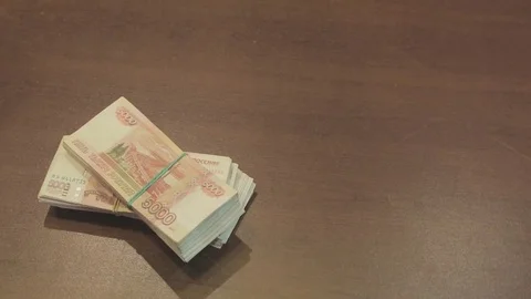 Bundle of banknotes on a table Видео 79159551