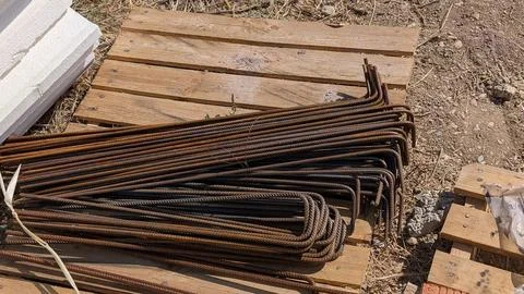 Bundle of bent steel reinforcing bars stacked on pallets at a building site Stock Photos