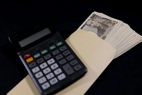 A bundle of bills by Japanese old banknotes with a envelope with calculator 스톡 사진