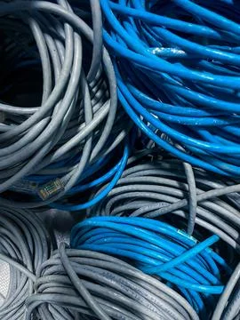 Bundle of blue and grey unused rolled LAN cable or network cable as backgroun Stock Photos