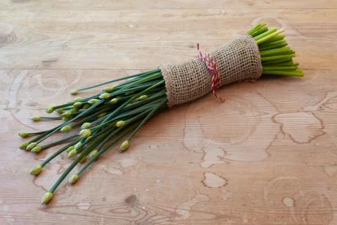 Bundle of chives, bound in burlap, low diagonal view on weathered wood Stock Photos