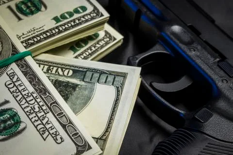 Bundle of dollars with a gun in a black bag Stock Photos