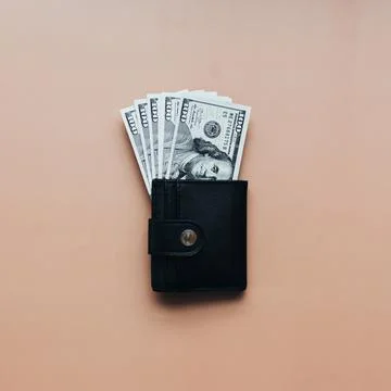 Bundle of dollars in purse on beige background Stock Photos