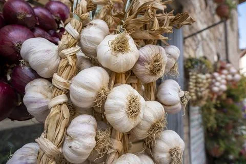 A bundle of dried garlic hanging outside on a wall Stock Photos