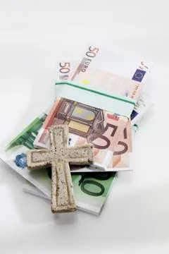 Bundle of euro notes with cross on white background Foto stock