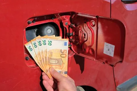 A bundle of fifty euro notes in font of a fuel tank Stock Photos