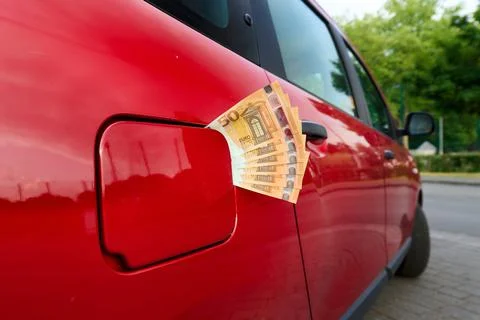 Bundle of fifty euro notes sticking out of a car's closed fuel tank Foto stock