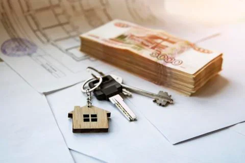 A bundle of five thousand notes with keys to an apartment or house on a white Foto stock