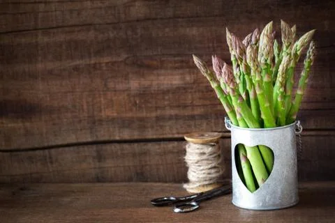 Bundle of fresh asparagus stalks on dark rustic wooden table Stock Photos