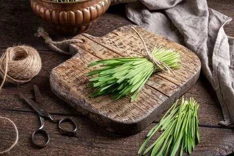 A bundle of fresh barley grass on a rustic table Foto stock