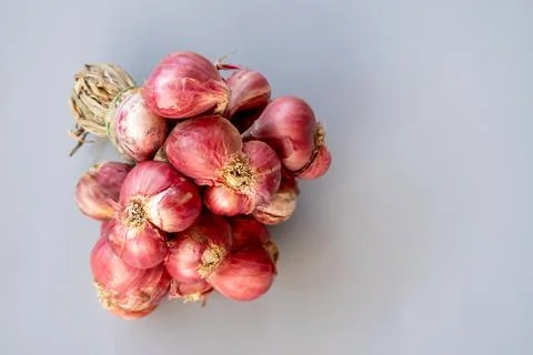 A bundle of fresh red shallots tied with dried straw. A symbol of tradition.. Foto stock