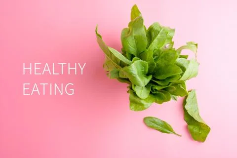 A bundle of fresh spinach on pink background healthy eating concept copy s[ac Stock Photos