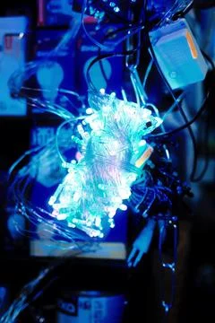 Bundle of glowing blue LED string lights in a dark room Stock Photos