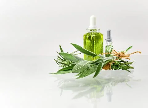 Bundle with herbs and bottles with extracts. Oil alcohol and water. Stock Photos