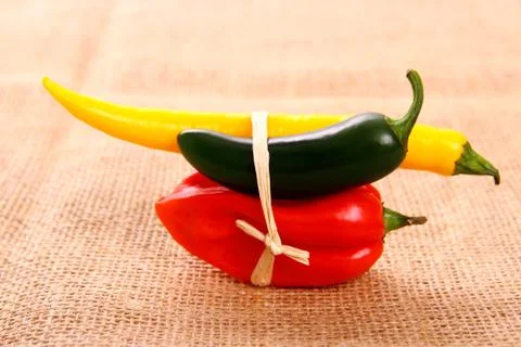 Bundle of hot pepper varieties of jute background Stock Photos