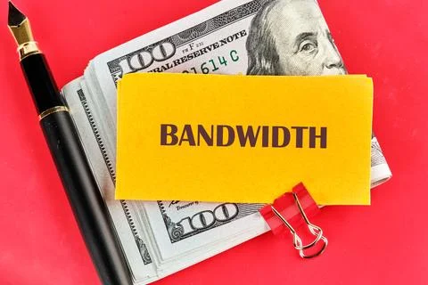 A bundle of hundred dollar bills alongside a yellow note labeled bandwidth il Foto stock