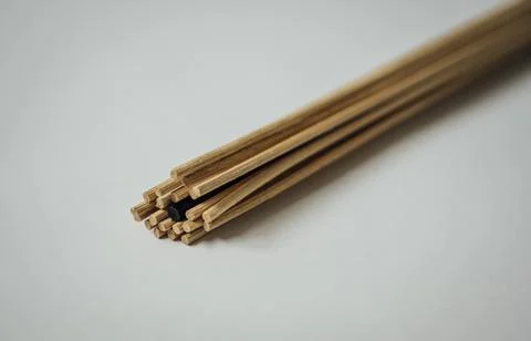 Bundle of light brown diffuser reeds with one black within Stock Photos