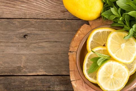 Bundle of mint and slices of lemon on old wooden background. Copy space. Top  Stock Photos