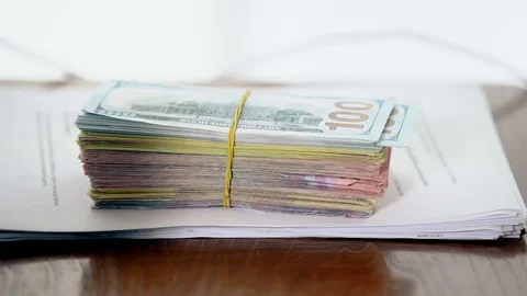 A bundle of money on the table, a lot of dollars in their hands, business people Stock Footage 100371599