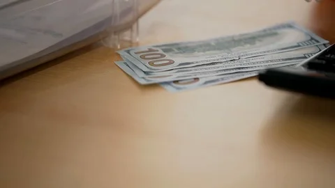 A bundle of money on the table, a lot of dollars in their hands, business people Stock Footage 100371788