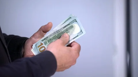 A bundle of money on the table, a lot of dollars in their hands, business people Stock Footage 100372021
